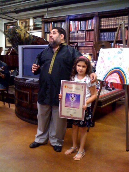 La niña Melisa Ortiz, que recibe de manos de Josán Caballero el Premio EGOGARABATO de Excelencia, y el Premio EGOBLOG de Excelencia, para nuestra colega Inés de Cuevas.