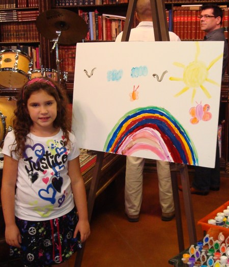 La niña Melisa Ortiz, mostrando su dibujo, y el bloguero Eddy Díaz Souza detrás, del blog Artedfactus.