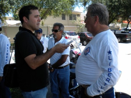 El periodista Juan Carlos Chávez, de El Nuevo Herald, mientras entrevista a Miguel Ángel González, organizador de la Caravana, por el Club de Motociclismo Liberty Motorcicle Association