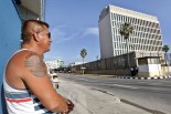 HAB13 LA HABANA (CUBA), 20/07/2015.- Un hombre con un tatuaje de las banderas de estados Unidos y Cuba observa el edificio de la embajada del país norteamericano en la isla hoy, lunes 20 de julio del 2015, en La Habana. Estados Unidos y Cuba escenificaron hoy el restablecimiento de sus relaciones diplomáticas tras casi 55 años de ruptura con la apertura en Washington de la embajada cubana. EFE/Ernesto Mastrascusa
