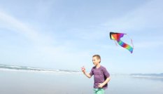 depositphotos_65819603-Boy-flying-kite-at-beach