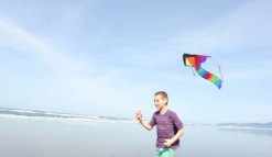 depositphotos_65819603-Boy-flying-kite-at-beach
